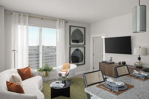 a living room with white furniture and a large window